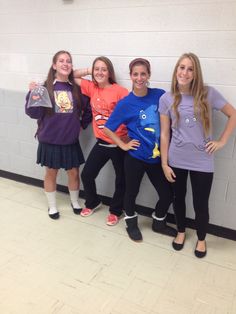 four girls are posing in front of a wall