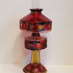 a red glass vase sitting on top of a table