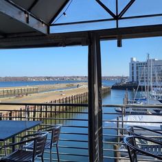 an outdoor dining area with tables and chairs overlooking the water