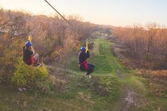 two people are zipping through the trees