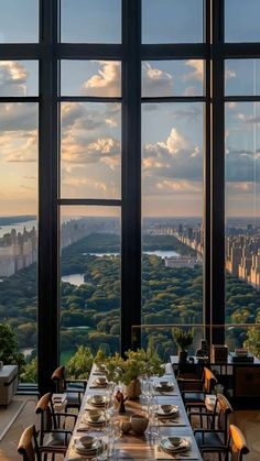 a long table with plates on it in front of large windows that overlook the city