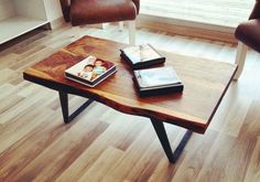 two chairs and a coffee table with books on it in front of a large window