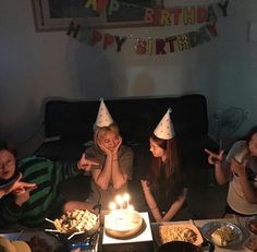 three children sitting around a birthday cake with candles on it