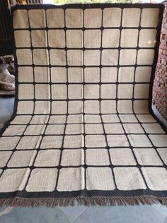 a blanket that is sitting on top of a chair with a black and white pattern