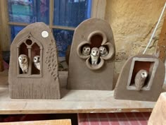 three cement sculptures with sheep in them on a table next to a window and windowsill