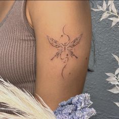 a woman's arm with a tattoo on it and flowers in the foreground