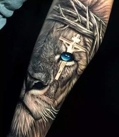 a lion with blue eyes and a crown on his head is shown in this tattoo