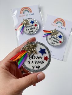 someone is holding two badges that say silver is a super star and one has a rainbow