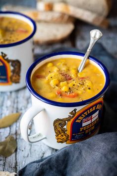 two white cups filled with soup on top of a wooden table