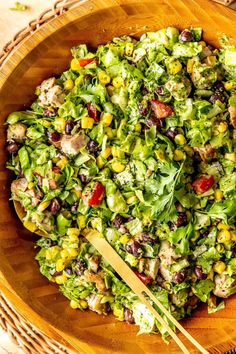 a wooden bowl filled with salad on top of a table