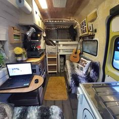 the interior of a camper with two beds and laptops on the counter top