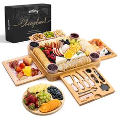 an assortment of cheeses, fruit and crackers on wooden trays with matching serving utensils