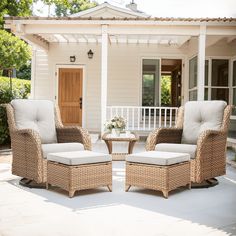 two wicker chairs and a small table in front of a house