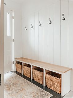 an entryway with baskets and hooks on the wall