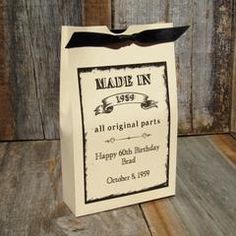 a white bag with black ribbon on it sitting on a wooden table next to a wall