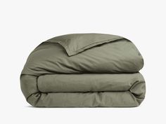 an olive green comforter and pillow on a white background with the sheets folded down