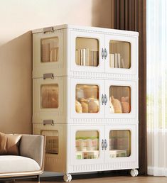 a living room with a couch, chair and white storage unit in front of a window