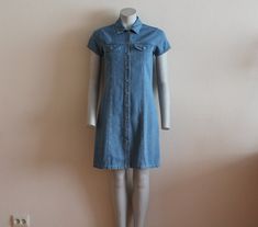 "Front Button Vintage Denim Dress Mini Denim Dress Jeans Dress Button Up Dress Short Sleeve Shirt Dress Grunge Denim Dress Small Label size: 160, estimated SMALL Measurements(lying flat): Shoulder: 14\"/ 35.5 cm Bust(pit to pit): 16.5\"/ 42 cm Sleeve: 5.5\"/ 14 cm Waist: 15 3/4\"/ 40 cm Length: 36\"/ 91.6 cm Please check measurements to insure a proper fit. Remember to allow yourself some extra room for movement. You can compare these with something from your closet that fits you well. Please co Denim Blue Cotton Dress With Buttons, Knee-length Cotton Denim Dress With Button Closure, Cotton Medium Wash Buttoned Shirt Dress, Cotton Medium Wash Shirt Dress With Buttons, Medium Wash Cotton Shirt Dress With Buttons, Fitted Chambray Denim Dress With Short Sleeves, Knee-length Denim Blue Dress With Buttons, Knee-length Cotton Denim Dress With Buttons, Button-up Cotton Denim Dress