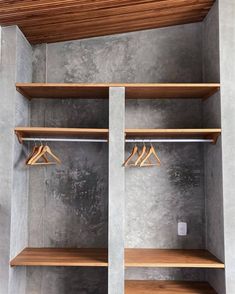 an empty walk in closet with wooden shelves