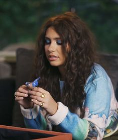 a woman sitting at a table with a cell phone in her hand and looking to the side