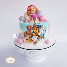 a birthday cake decorated with the characters of paw patrol on it's top tier