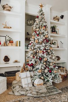 a white christmas tree with red and gold ornaments