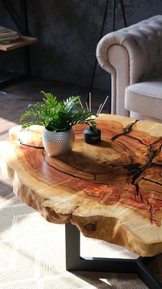 a wooden table topped with a potted plant on top of it next to a couch