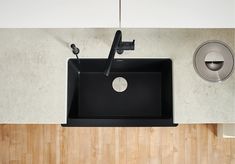 a black sink sitting on top of a wooden counter next to a faucet