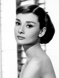 a black and white photo of a woman's face in front of shutters