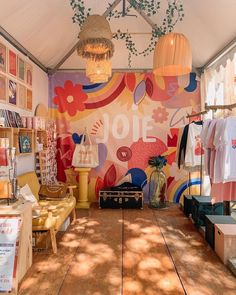 the inside of a tent with clothes on display