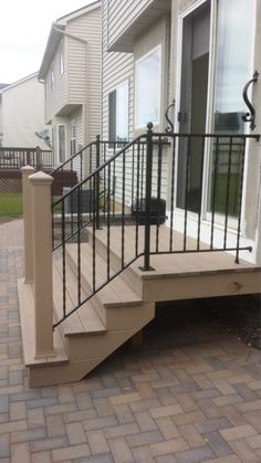 a dog is sitting on the front steps of a house with its head resting on the handrail