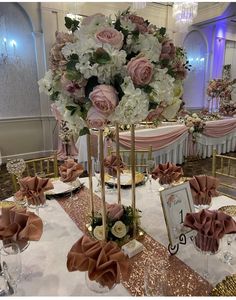 a table set up with pink and white flowers