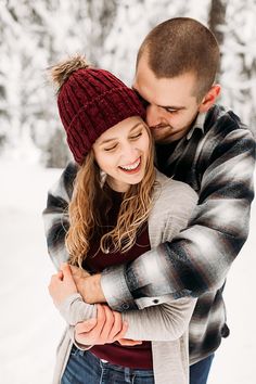 a man and woman hugging in the snow