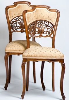 two wooden chairs with carved back and upholstered seat