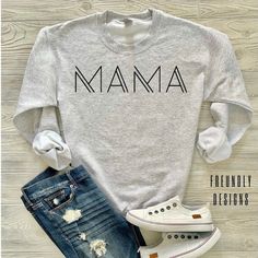 a gray shirt with the word mama printed on it and ripped jeans, white sneakers