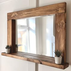 a mirror hanging on the side of a wall next to a potted succulent