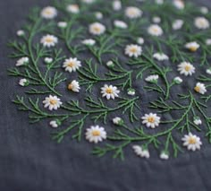 a close up of a piece of cloth with daisies on it and green stems