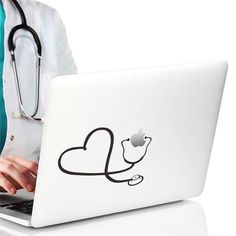 a doctor is typing on her laptop while wearing a stethoscope and holding a stethoscope