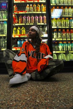 a person sitting on the ground in front of a store