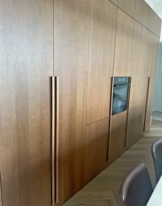 a kitchen with wooden cabinets and chairs in it