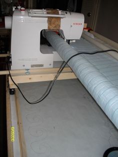 a sewing machine sitting on top of a piece of plywood being worked on by someone