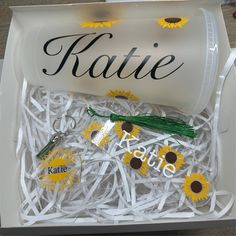 an open box with sunflowers and keychains in it that say kate