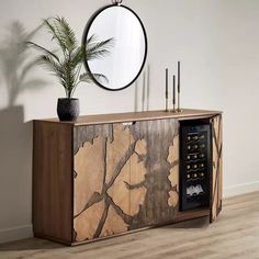 a wooden cabinet with a plant and mirror on it's sideboard next to a potted plant