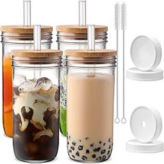 four mason jars with lids and spoons filled with drinks