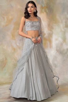 Grey Hand Embroidered Lehenga Set Featuring a grey lehenga in georgette base with sequins, cutdana, aari, beads and crystal hand embroidery. It is paired with a matching cutwork blouse and a net dupatta. This product will be shipped to you after 1-2 weeks from the date of order placed. All custom made orders are not returnable. Pls contact for Size chart and for other more colors Request You :To provide contact details for courier services. {VARIATION MAY COME DEPENDING UPON AVALIBILITY OF LACES OR GOTTA PATI} NOTE:  1) Visual Samples on website may differ slightly from actual product due to light & effects during photography (Length & Breadth have 1 n 1.5 inches +/-). 2) Before placing order ,pls confirm product n color availability on +91 7903893945 & +91 8447750028(WhatsApp) 3) For Whol Grey Lehenga, Cutwork Blouse, Independance Day, Lehenga Blouse Designs, Net Lehenga, Embroidered Lehenga, Lehenga Blouse, Embellished Blouse