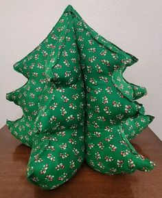 a green christmas tree sitting on top of a wooden table