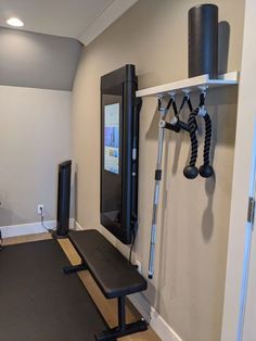 a home gym area with equipment on the wall