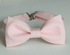 This trendy and stylish bow tie is great for so many occasions!Bow tie made of 100% cotton with a matching, adjustable neck strap. Style:• The Pre-Tied Bow Tie• The Clip-On Bow TieAll our bow ties can be made in the following sizes, just specify which size you need in a note at checkout: Sizes:Baby: 3.5" x 2"Kids: 4" x 2"Youth: 4.25" x 2.25Adult: 5" x 2.5"All our bow ties are made by hand; therefore, measurements are a guideline only and cannot be guaranteed. Neck strap sizes:Baby – adjustable t Pink Bow With Bow Tie Back For Wedding, Pink Bow Tie With Detachable Bow For Party, Pink Formal Bow With Bow Tie Back, Elegant Pink Bow For Black Tie Events, Elegant Pink Bow Tie For Black Tie Events, Pink Elegant Bow Tie With Decorative Bow, Pink Satin Bow For Black Tie Events, Elegant Pink Bow Tie With Decorative Bow, Elegant Pink Bow Tie Fitted