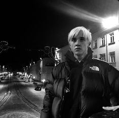 a man standing on the side of a road at night