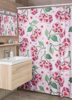 a bathroom with a pink shower curtain, sink and wooden cabinet in it's corner